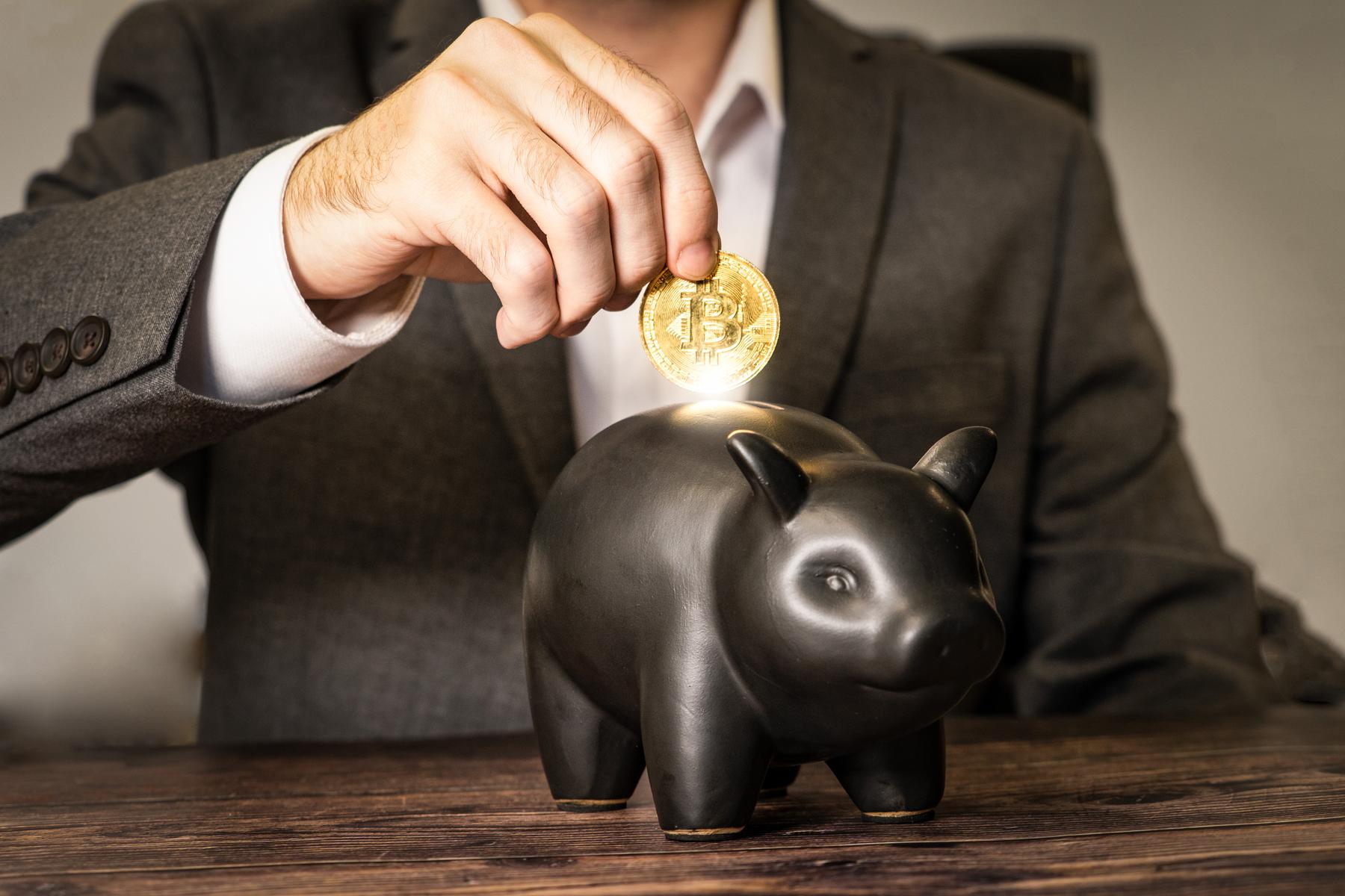 Cryptocurrency Savings & Investments - a man in a suit and tie tie holding a coin in a piggyo piggyo